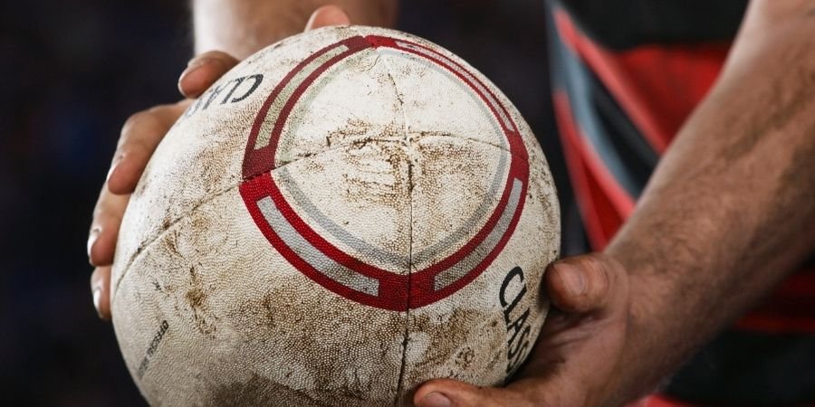 Joven sujetando un balon de Rugby