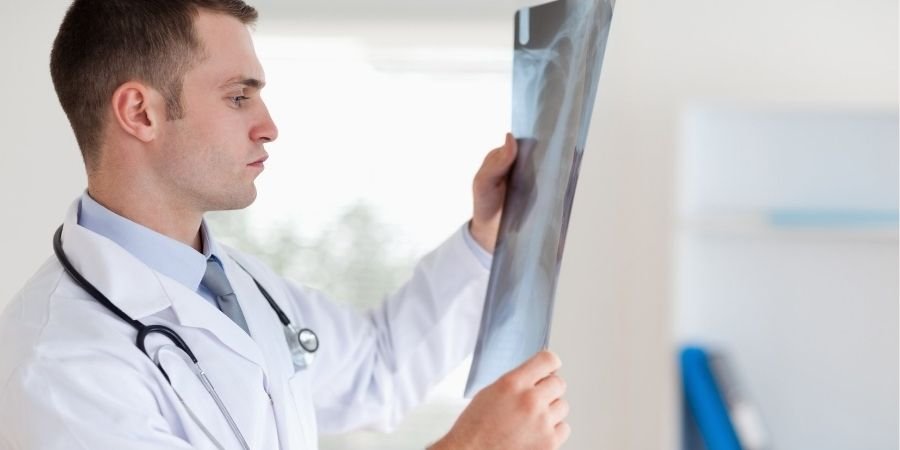 Empleado del sector salud trabajado en Irlanda con una radiografía en la mano